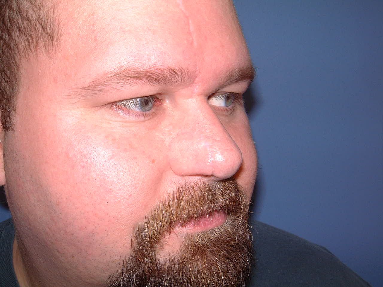 A man with a beard and blue eyes is looking at the camera.