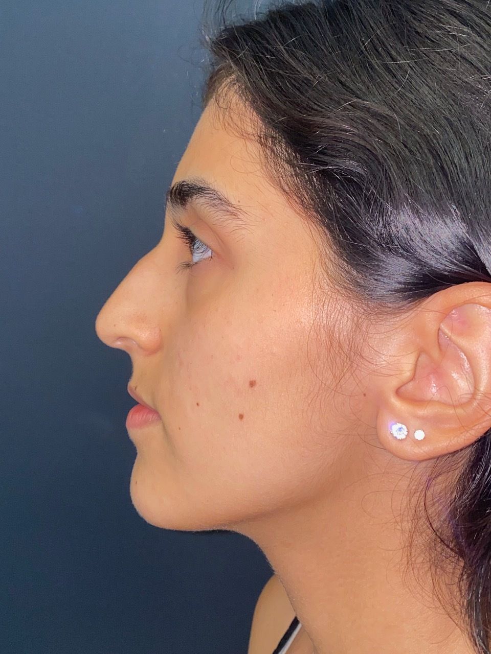 A close up of a woman 's face with earrings in her ears.