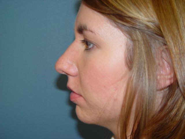 A close up of a woman 's face with a nose ring.