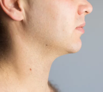 A close up of a man 's neck and ear.