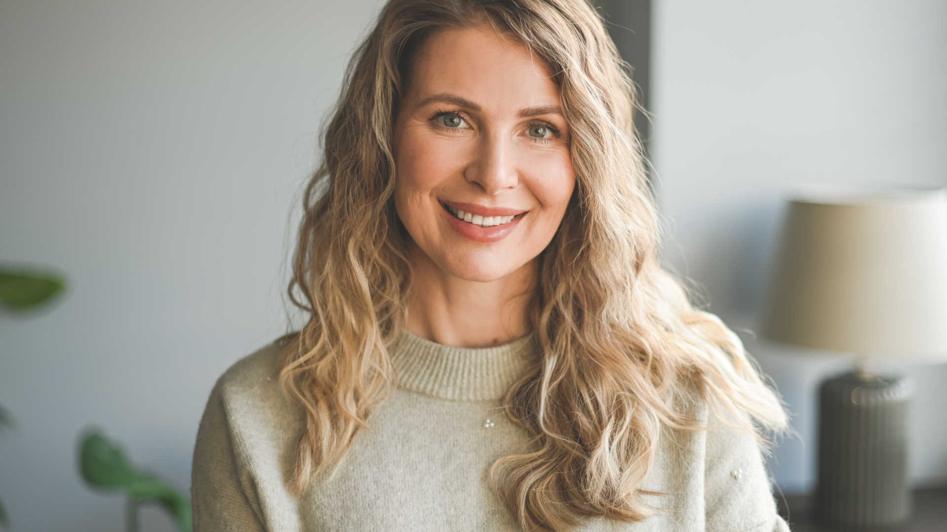 A woman in a white sweater is smiling for the camera.