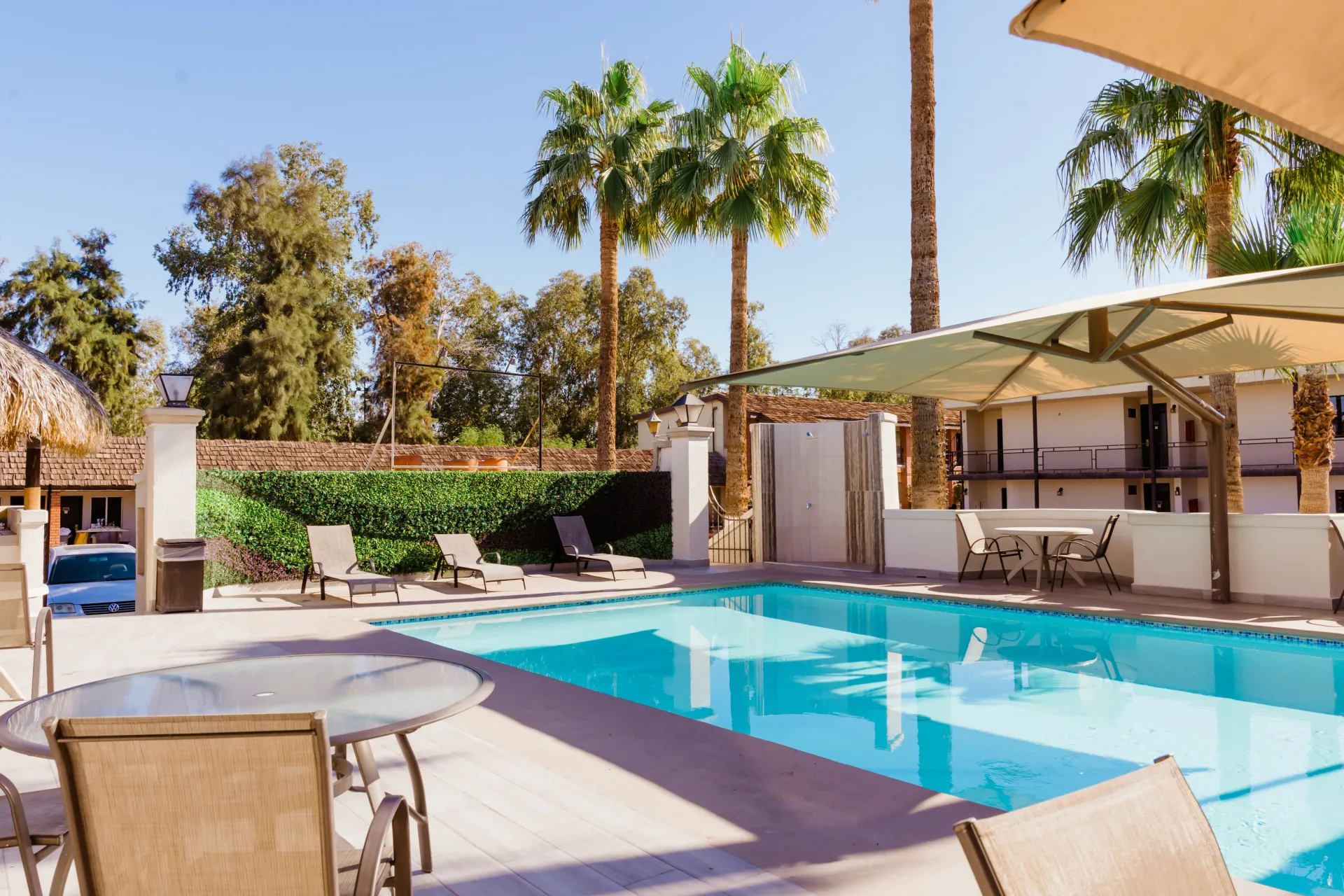 A large swimming pool with tables and chairs around it