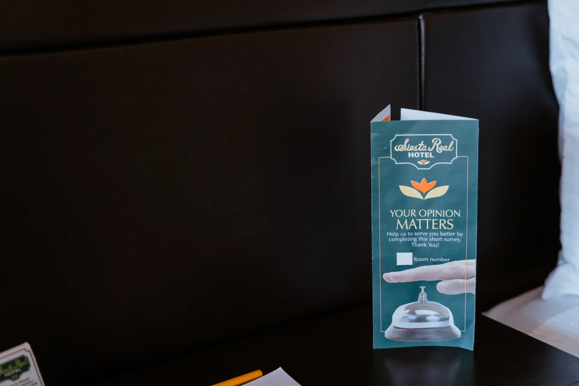 Un panfleto está sobre una cama al lado de una campana.