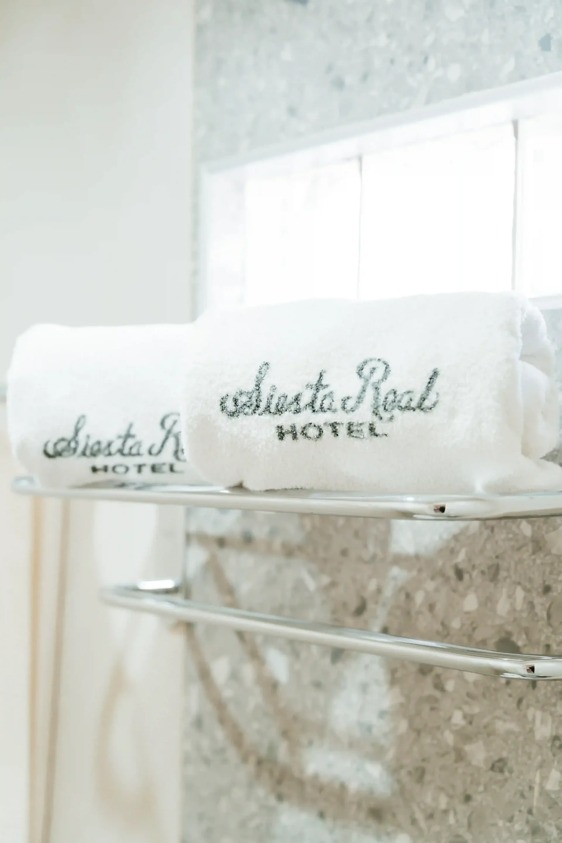 Dos toallas blancas enrolladas con el logotipo del