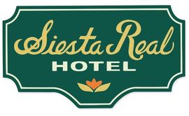 Un cartel verde que dice Siesta Real Hotel.