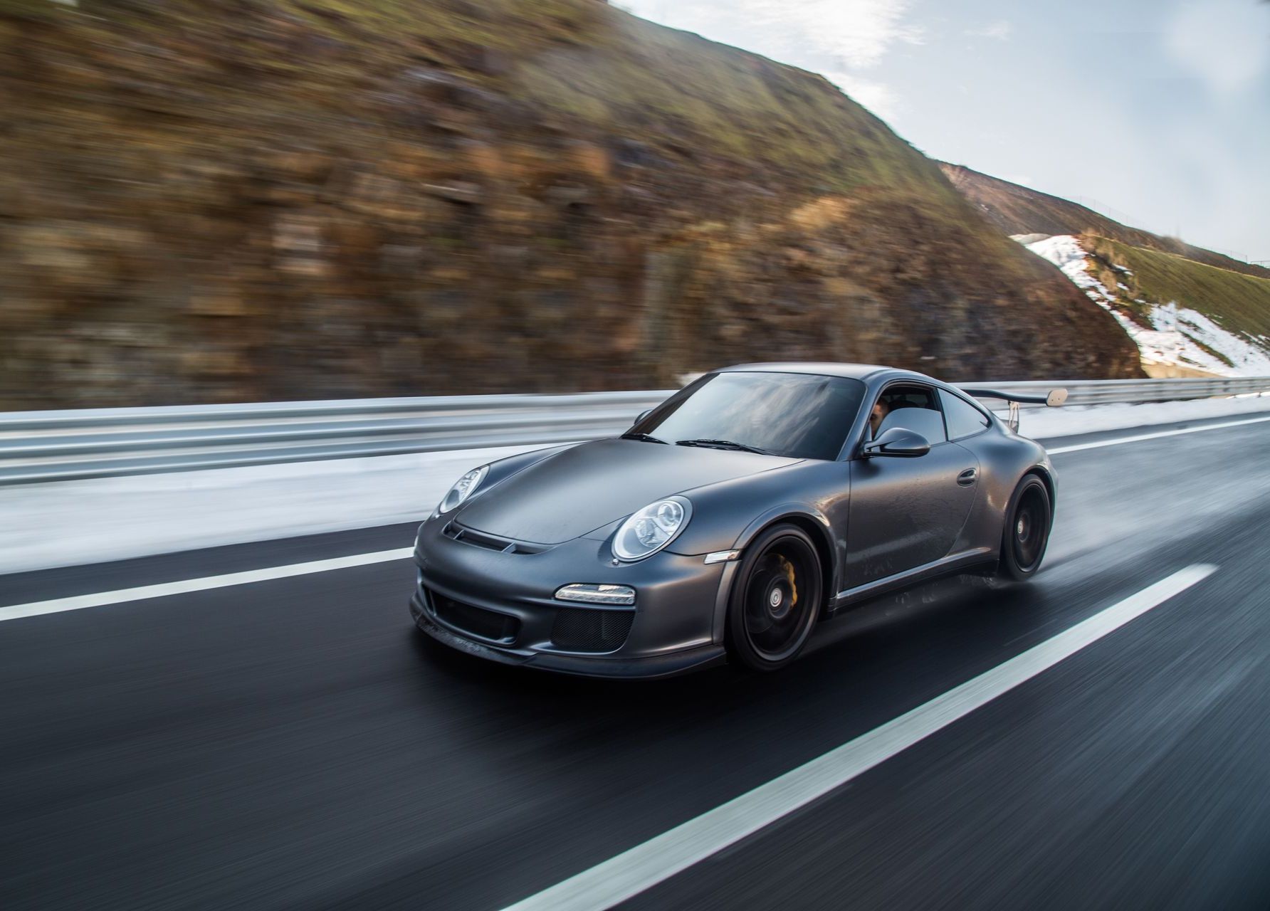 Ein Porsche 911 GT3 RS fährt eine verschneite Autobahn entlang.