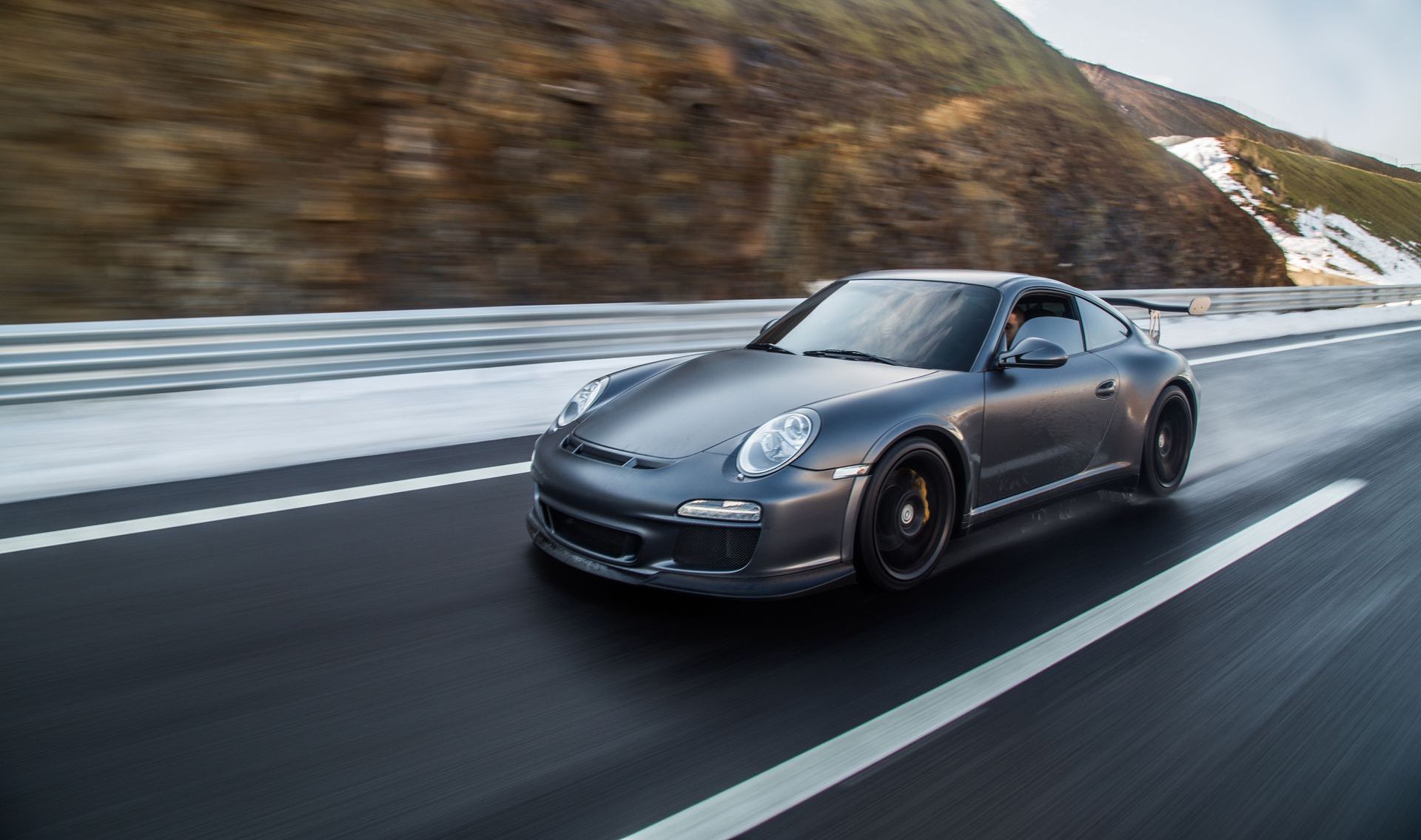 ein schwarzer Porsche fährt entlang einer schneebedeckten Landschaft