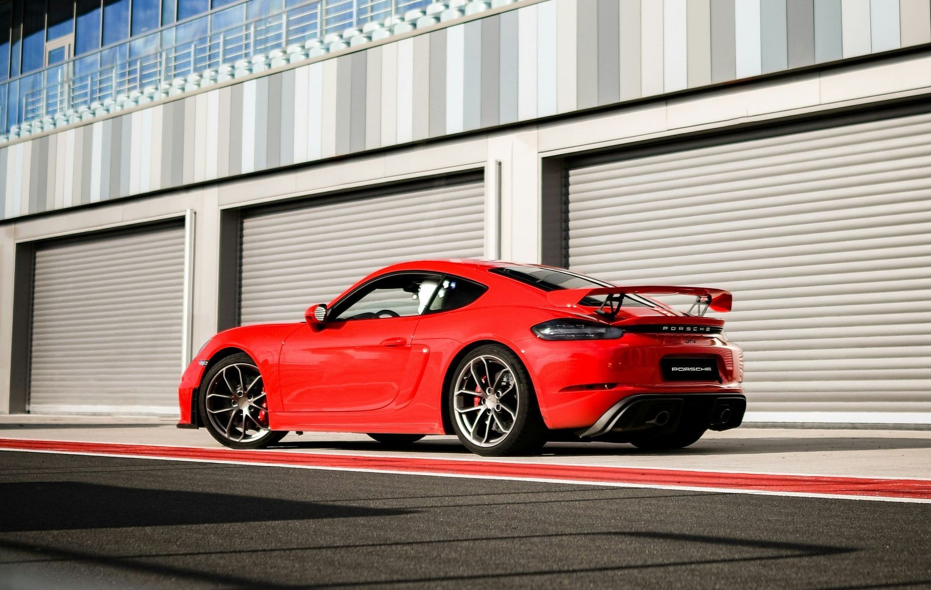 Ein roter Porsche steht vor einem Garagentor