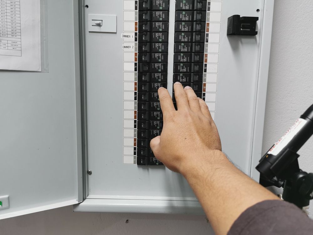 A person is pressing a button on an electrical box.