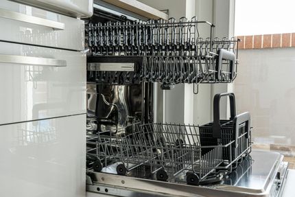 Open dishwasher interior with two racks, ready to load dishes.