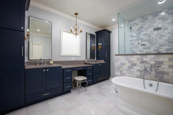 Navy blue bathroom with double vanity, walk-in shower, and freestanding tub.