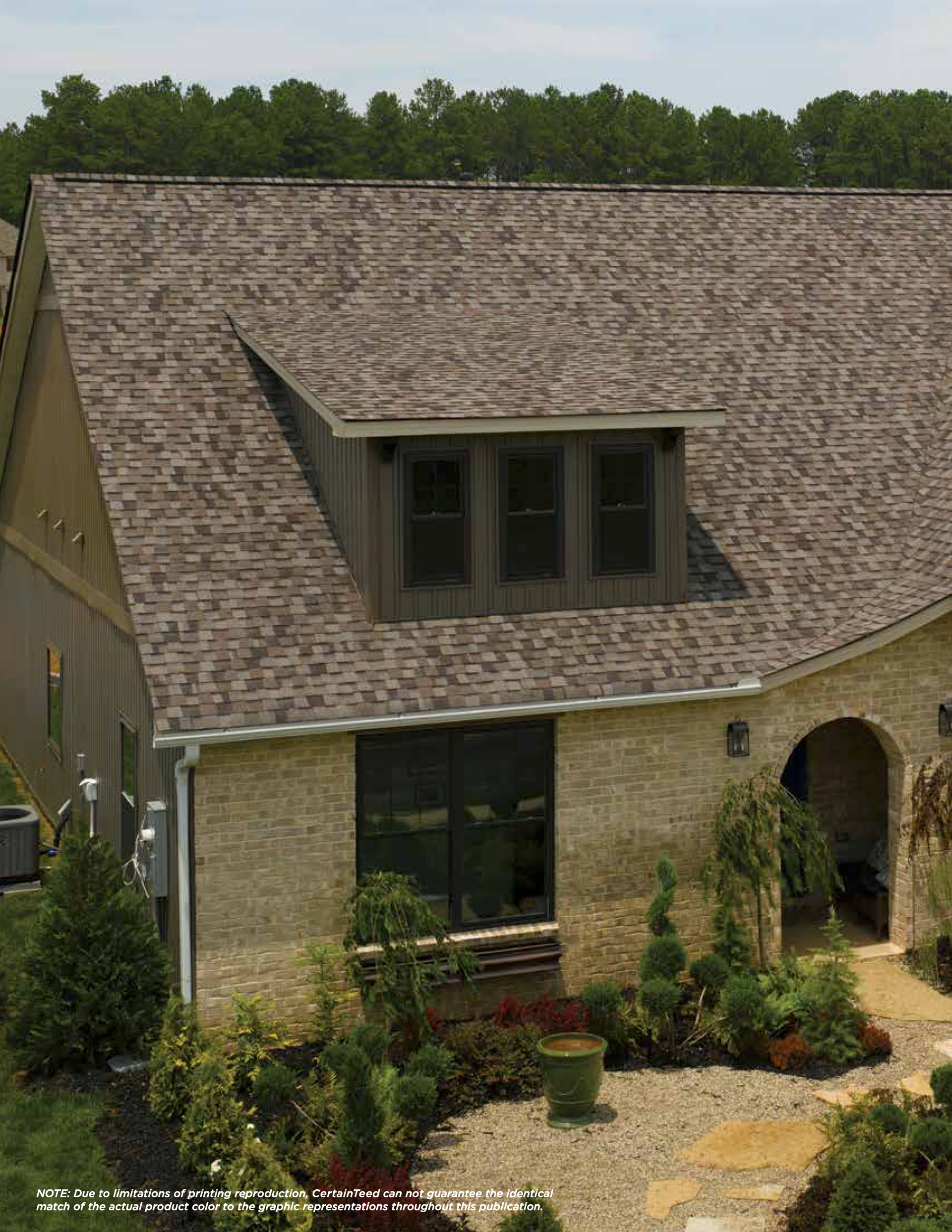 A brick house with a roof that has a dormer on it