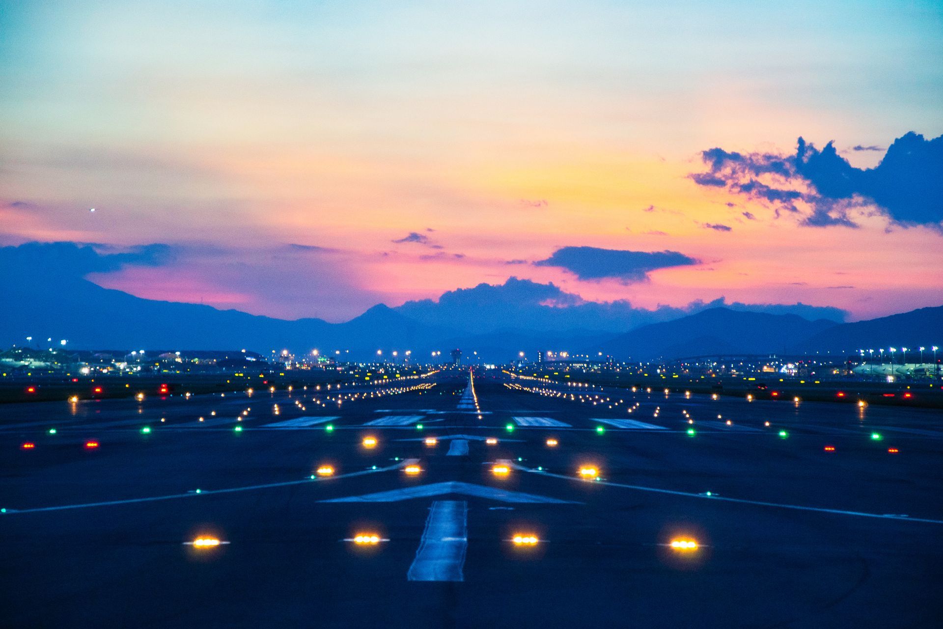 Airfield ground lighting on a runway, sunrise time at an airport.