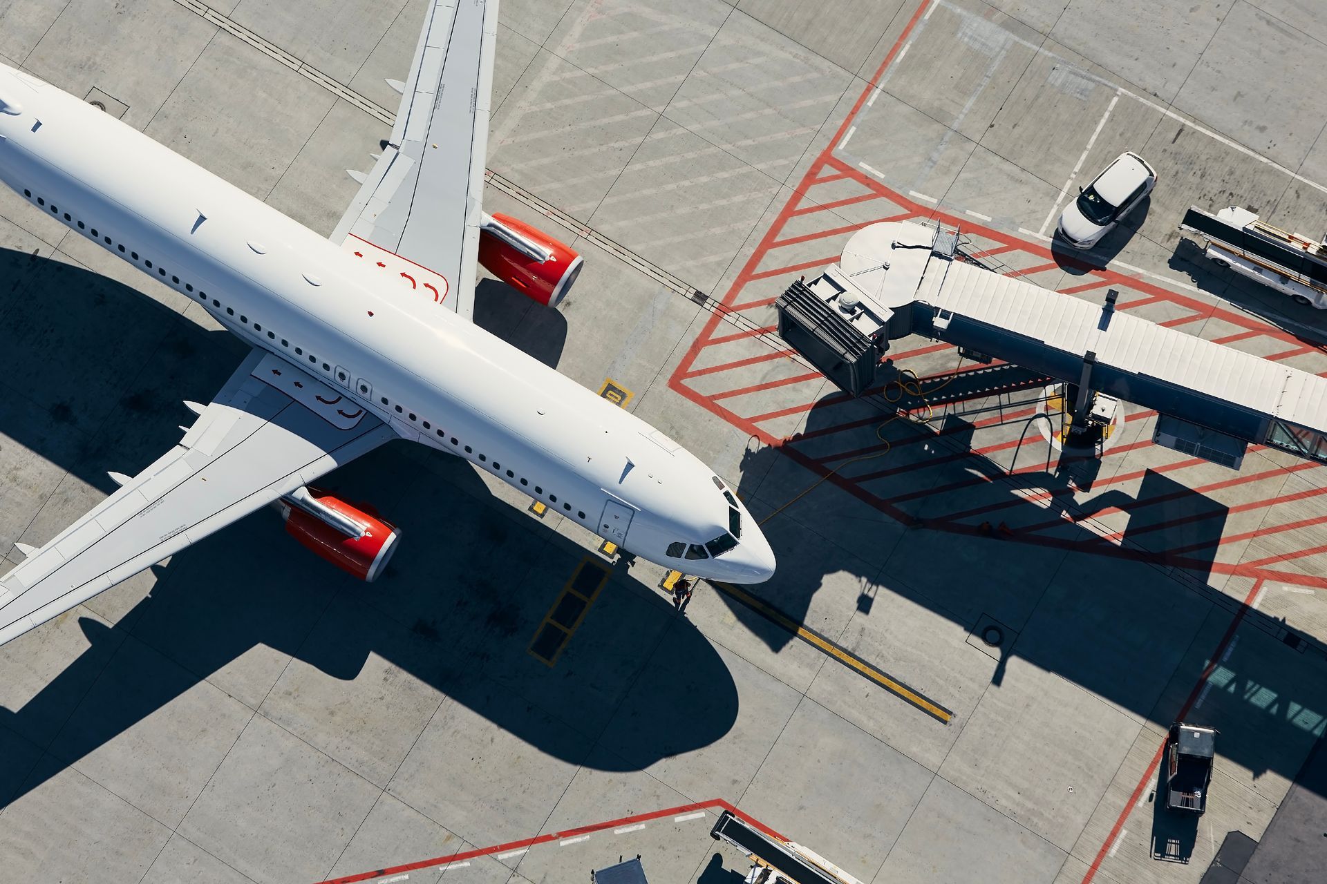Airplane parked at a gate; a jet bridge connects to the aircraft. 