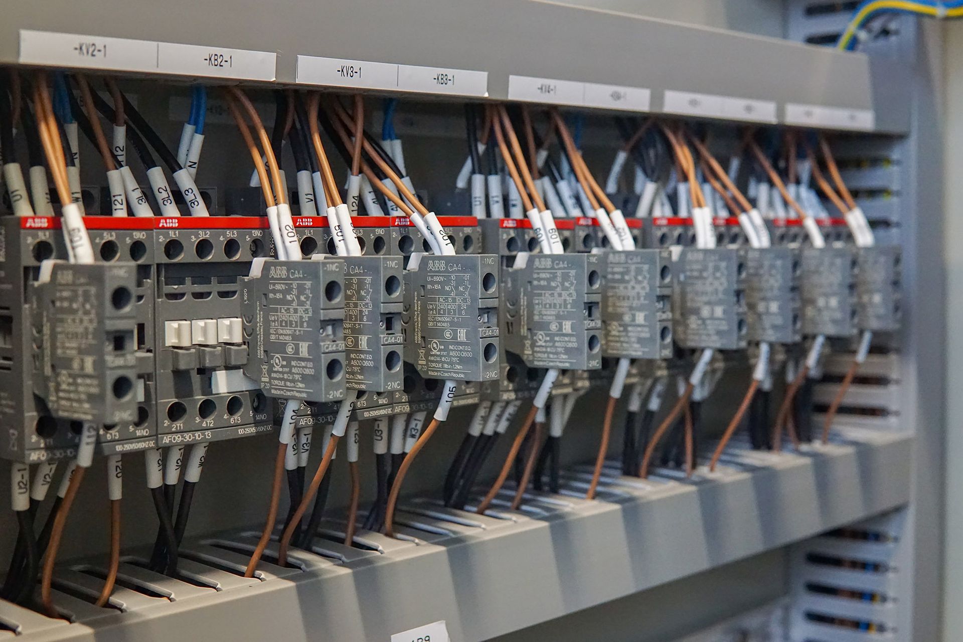 Electrical control panel with wires connected to relays and terminal blocks.