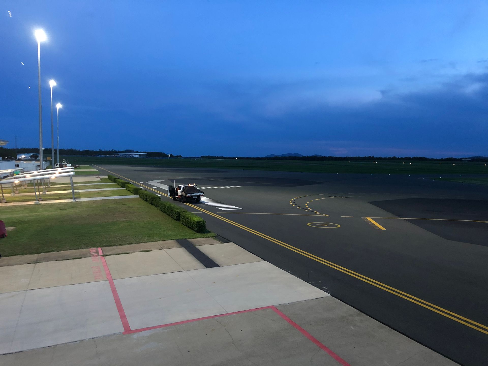 Tall metal light pole with multiple lights, against a blue sky with white clouds.