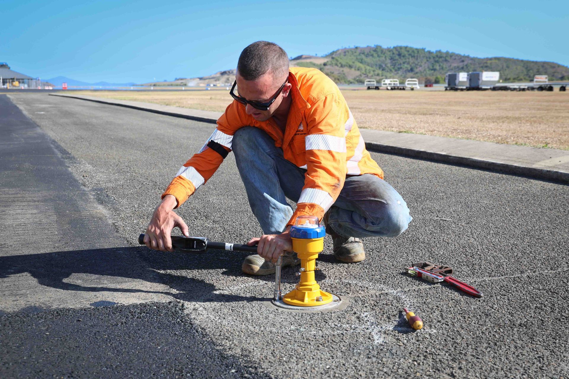 Runway lights illuminate a wet runway under a cloudy, dark sky.
