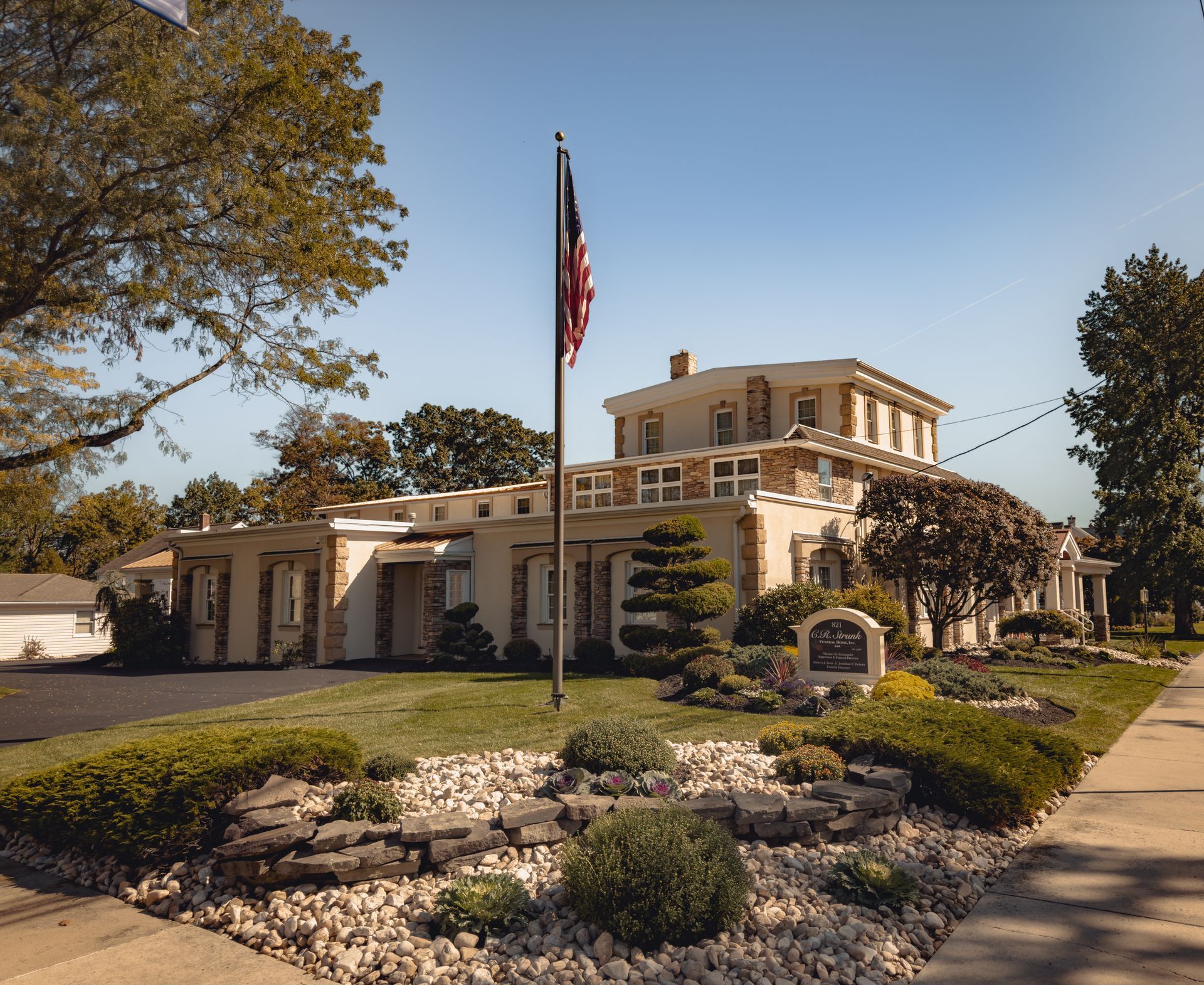 A funeral home with a black awning over the door