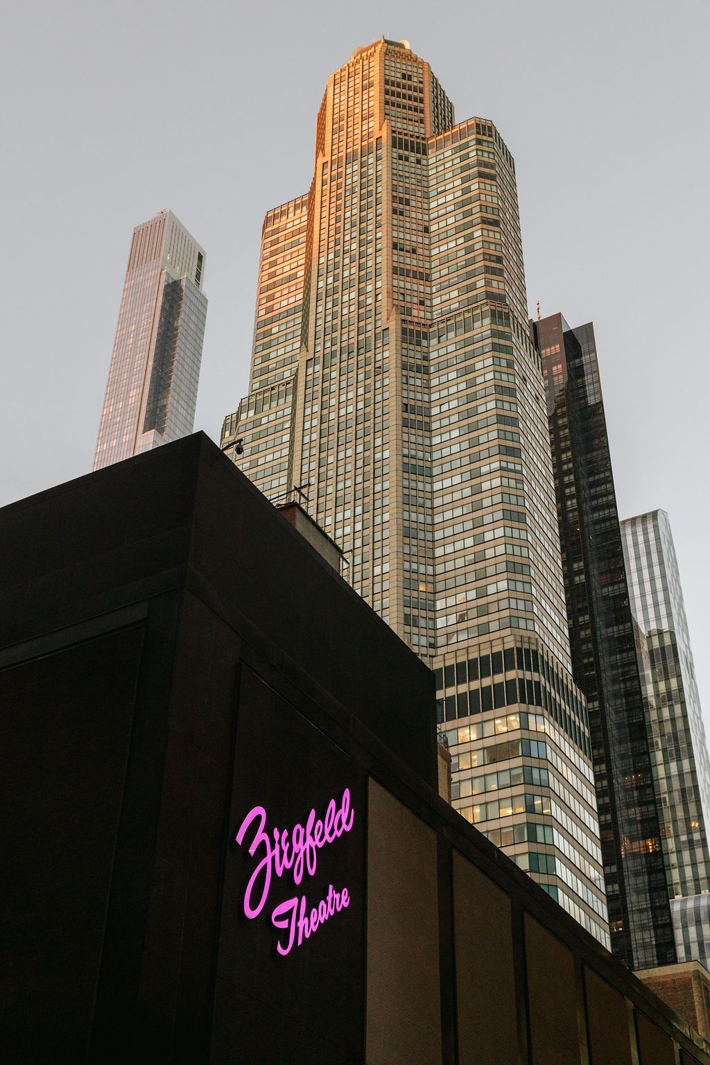 A tall building with a sign theater below.