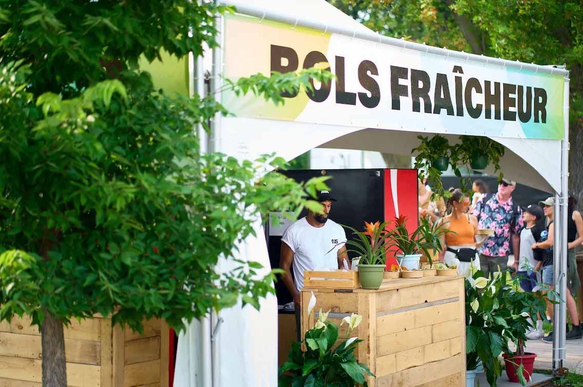 Stand « PGLS Fraicheur » avec du personnel. Façade en bois, plantes, enseigne.