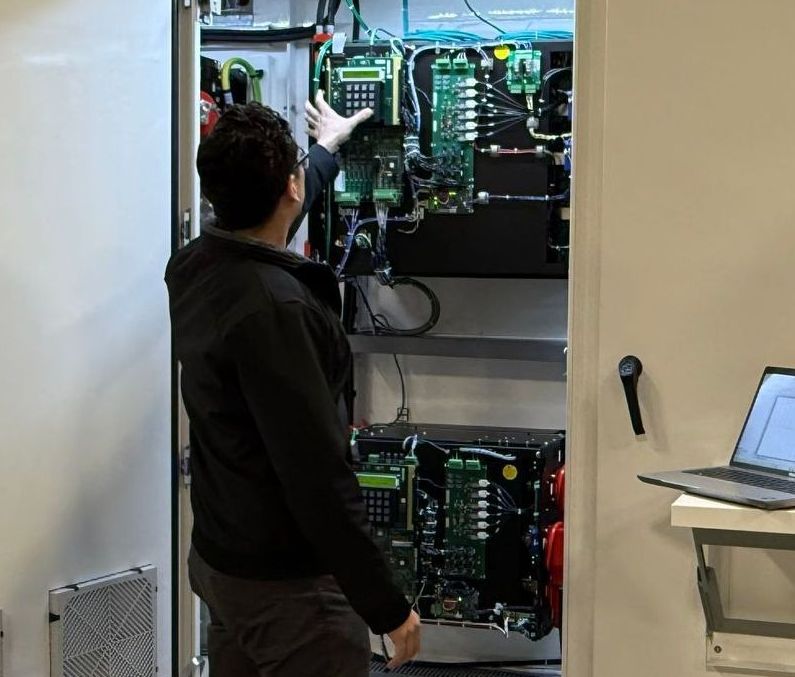 A man in a black jacket is working on a computer
