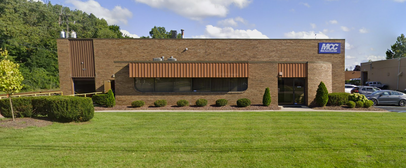 A large brick building with a lawn in front of it