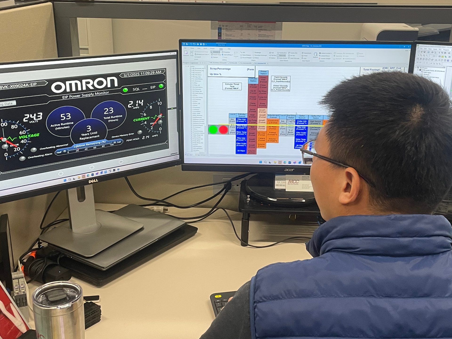 A man is sitting at a desk in front of two computer monitors.
