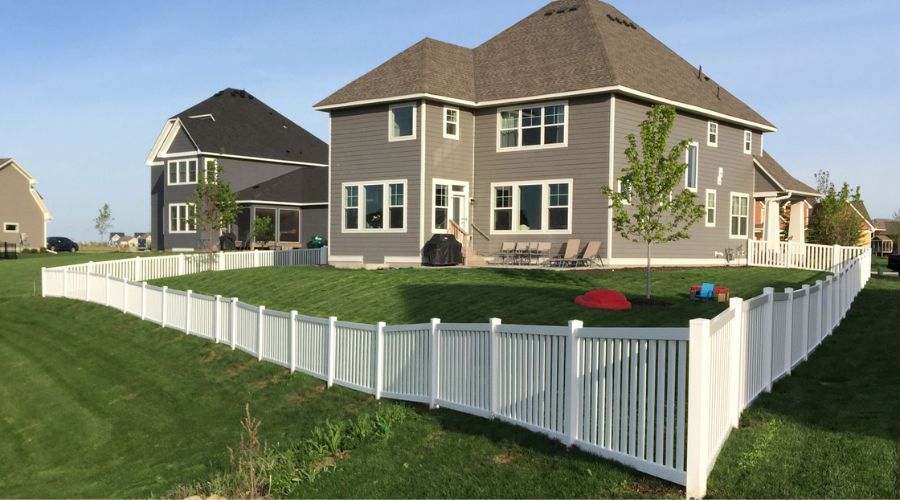 White vinyl picket fence surrounding a residential backyard in the Twin Cities.