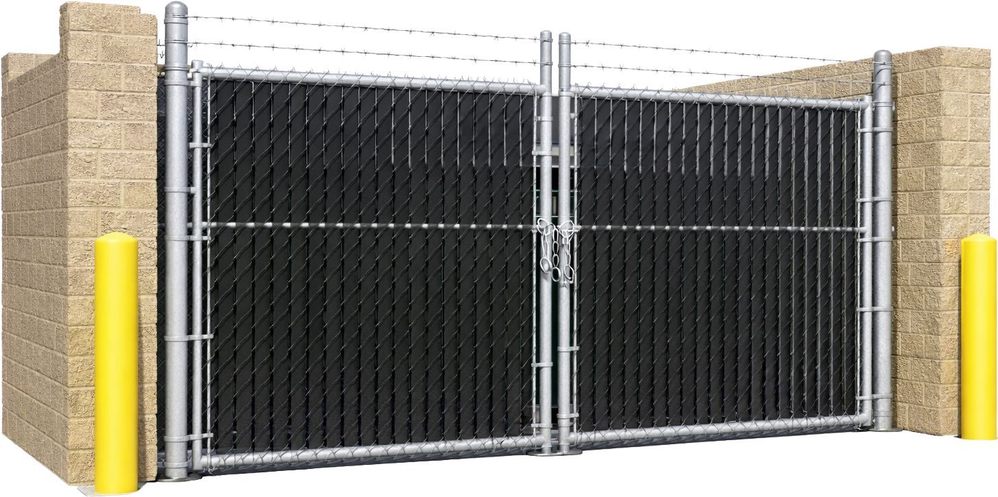 A double-gate chain-link fence with black privacy slats and barbed wire, flanked by brick walls and yellow bollards.