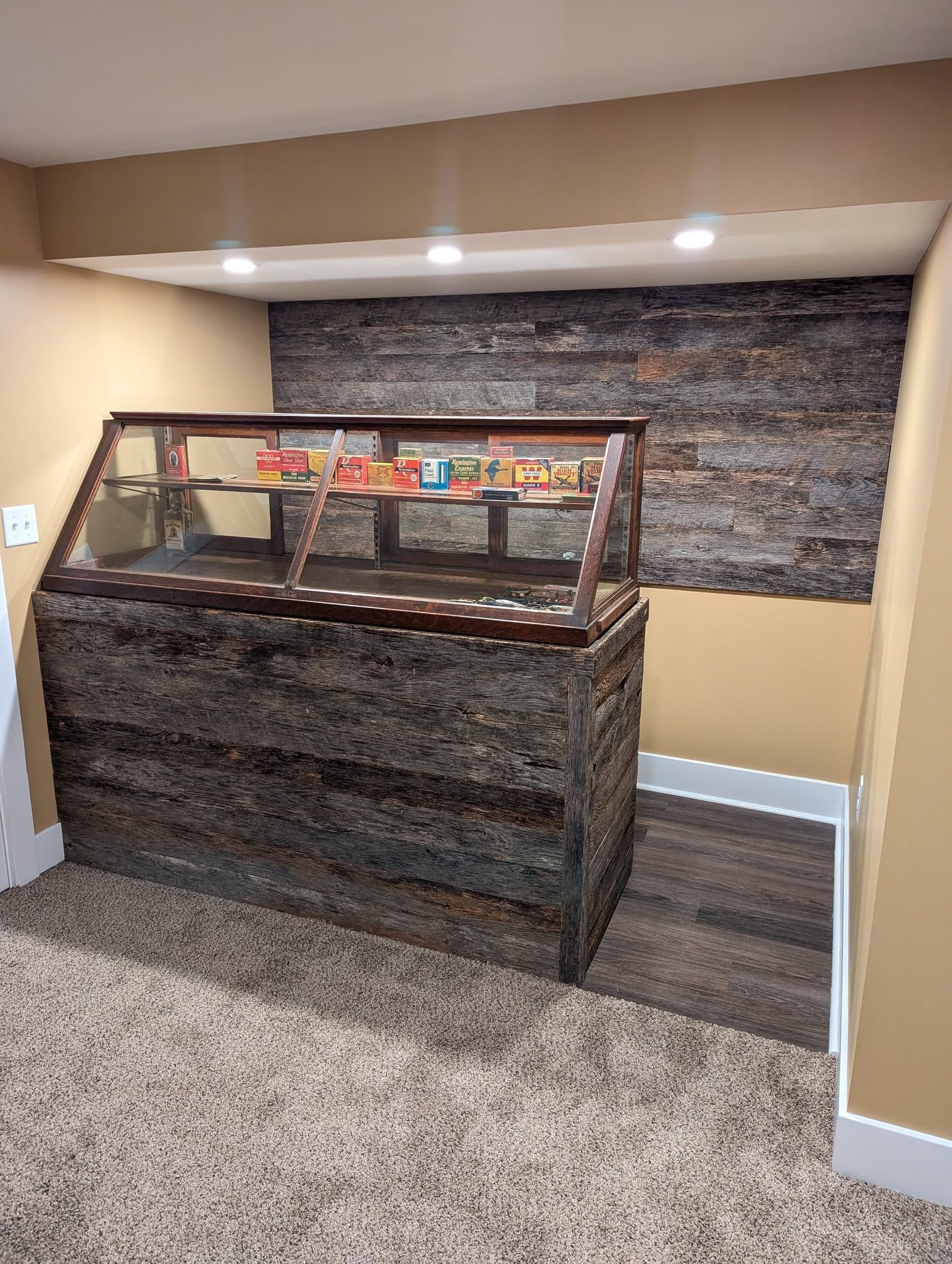 Woman in straw hat smiles, holding wine glass near a lake.