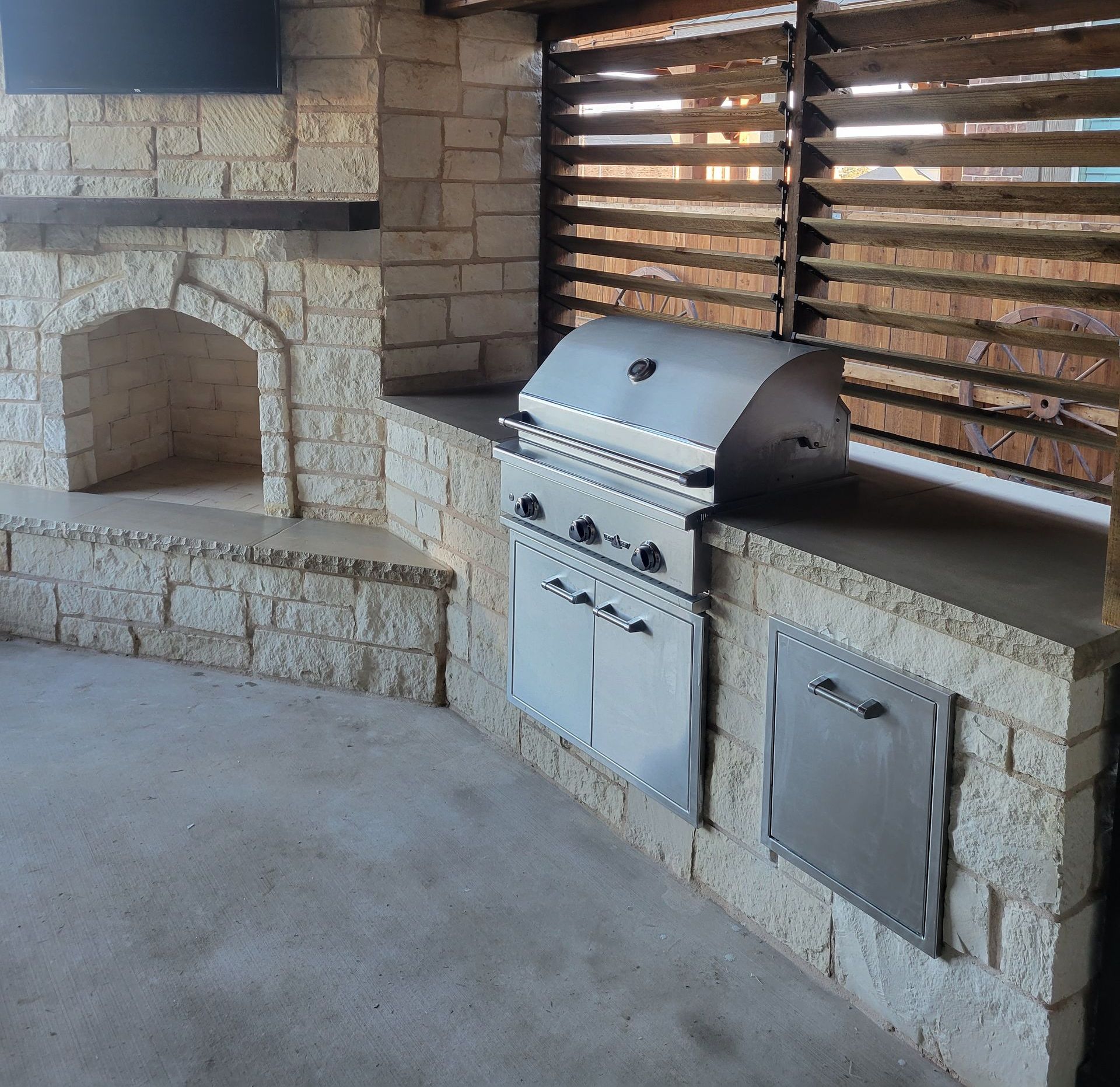 Full grill area with a stone fireplace