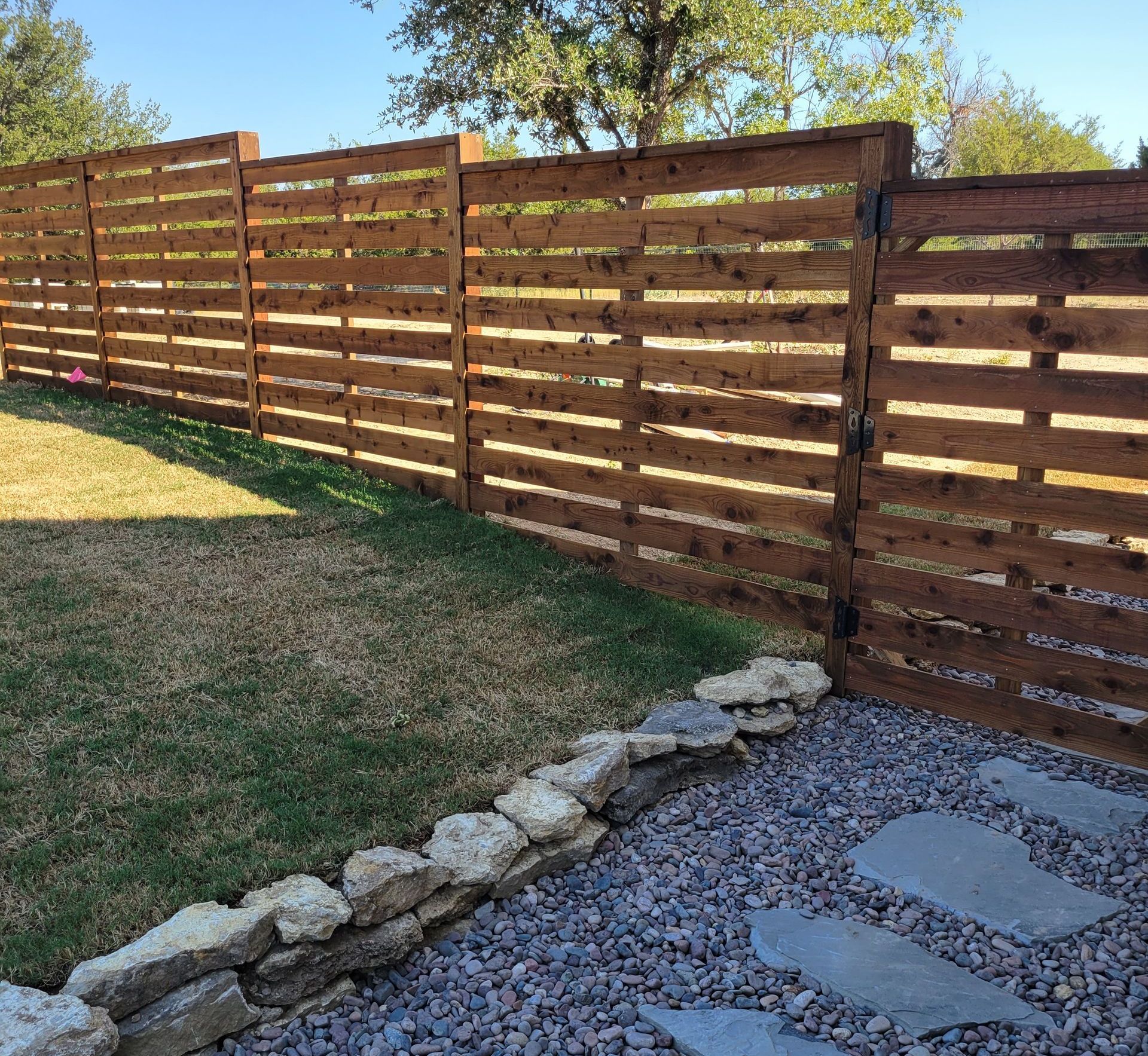 Custom cedar wood fence with natural stepping stones