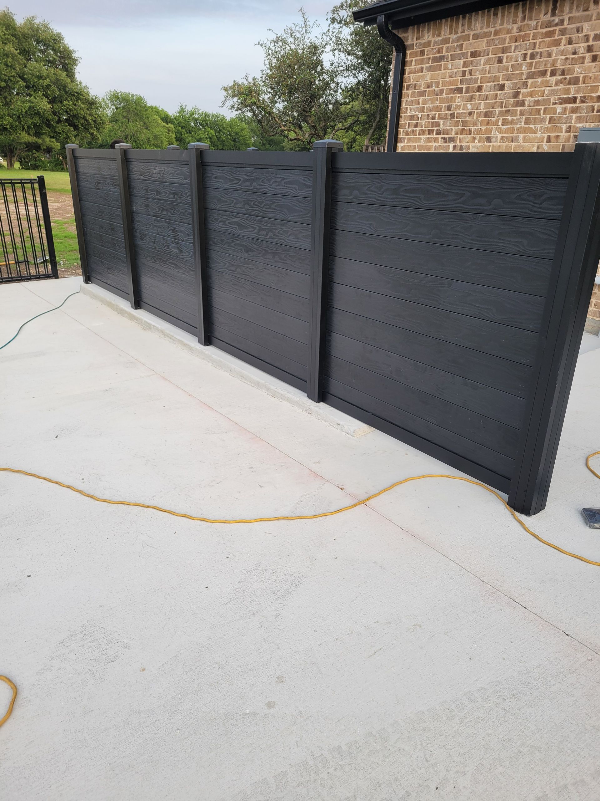 Ft Worth Fence And Patio has a new black vinyl fence for privacy.