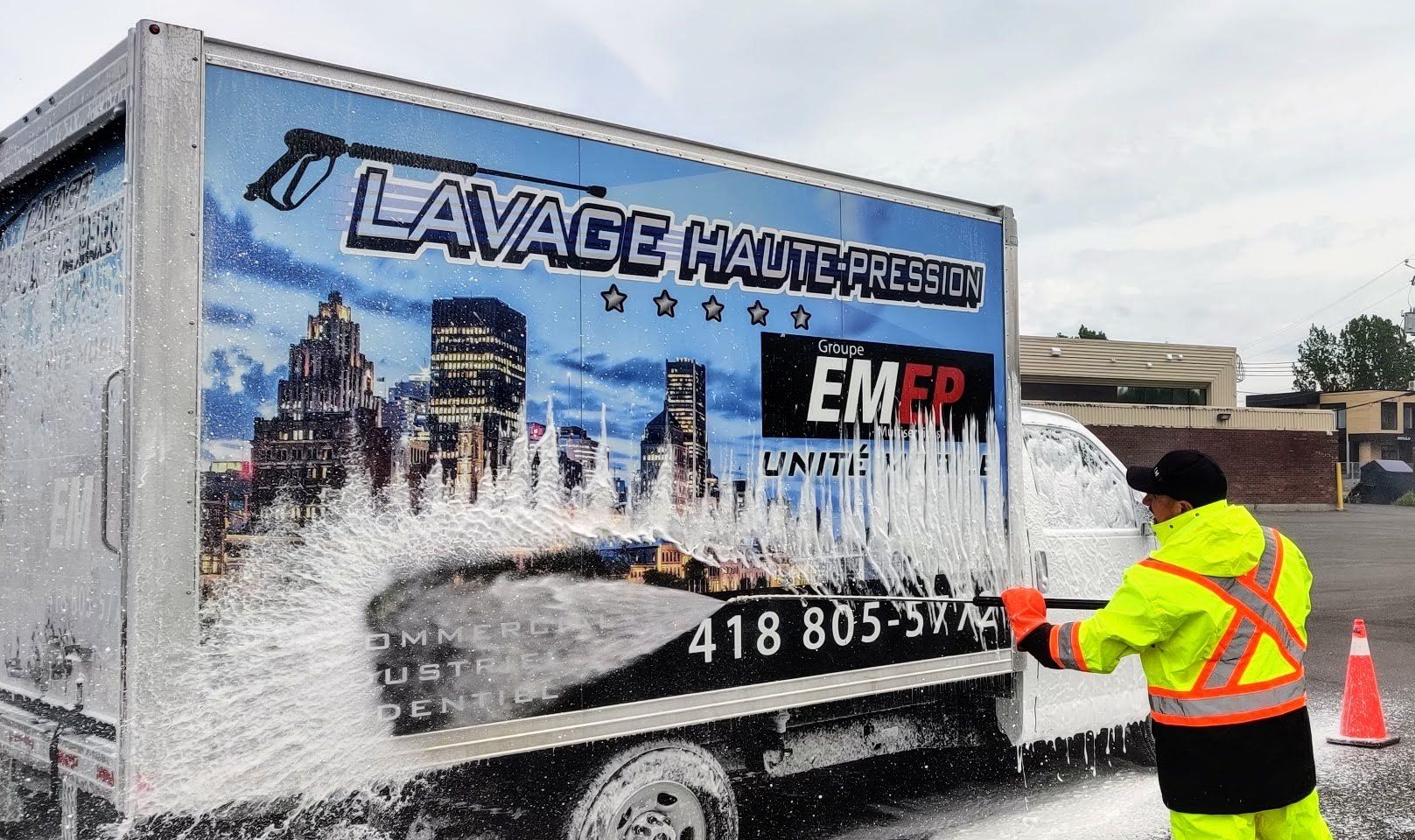 Un homme lave un camion avec un nettoyeur haute pression.