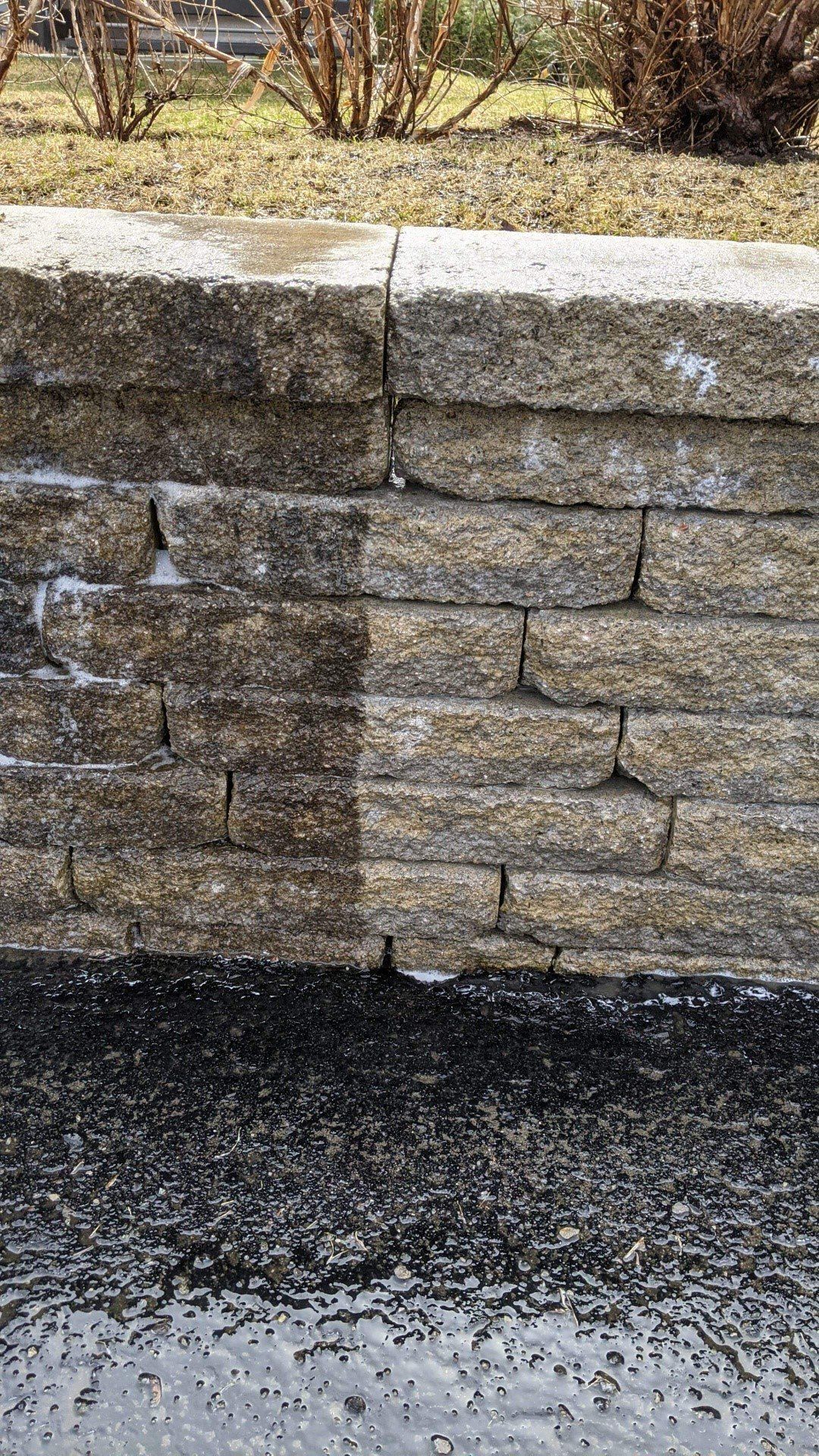 Un gros plan d'un mur de pierre à côté d'une route.