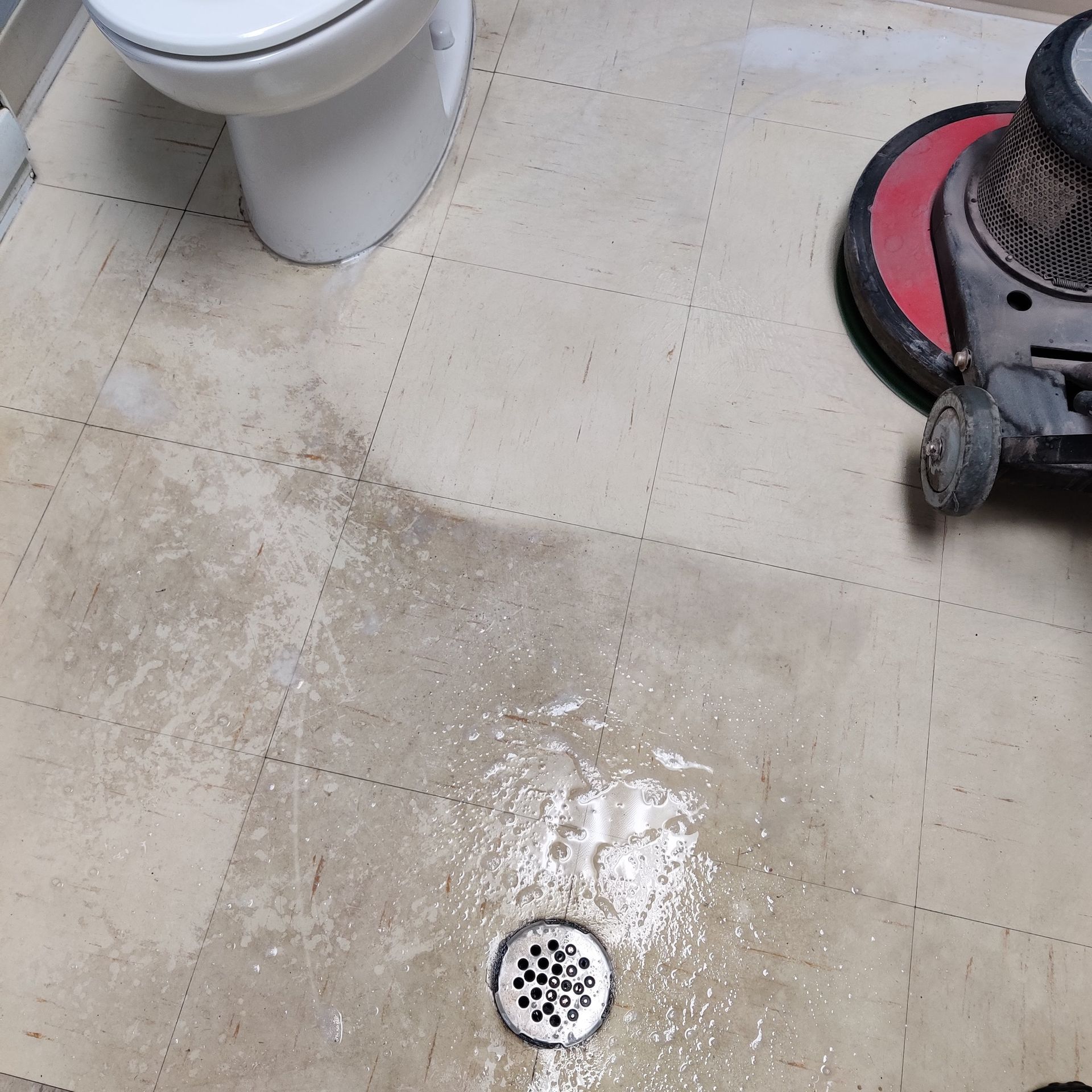 Un sol de salle de bain avec des toilettes et un drain