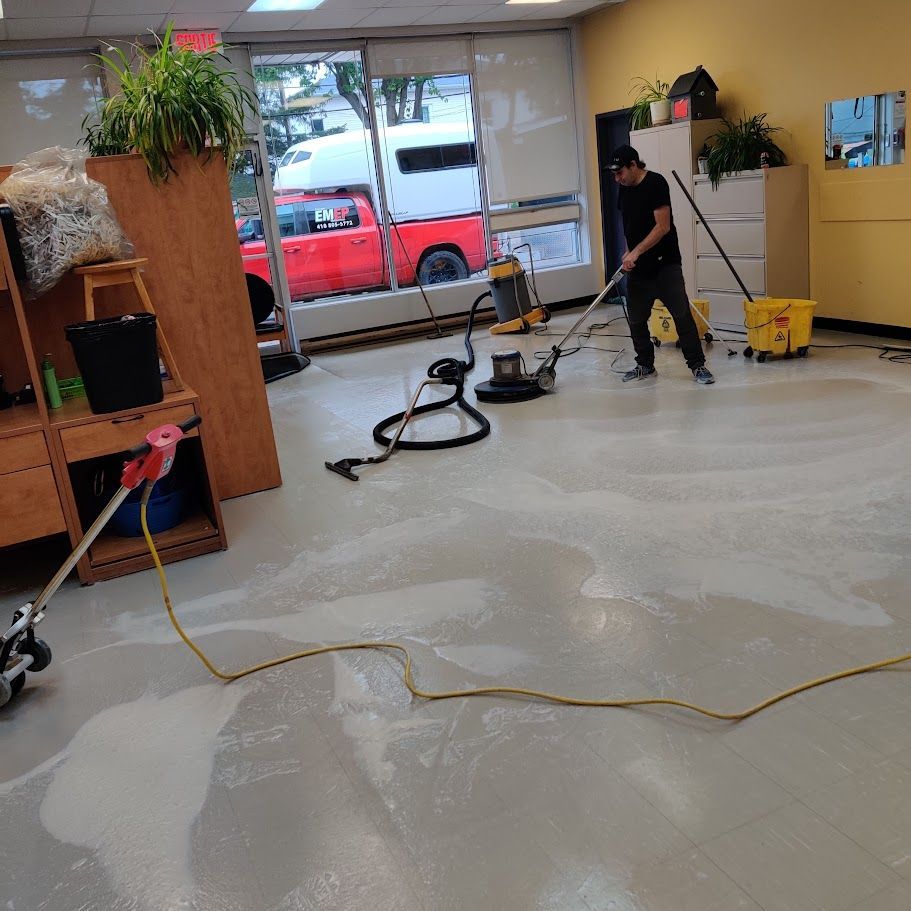 Un homme nettoie le sol avec un aspirateur
