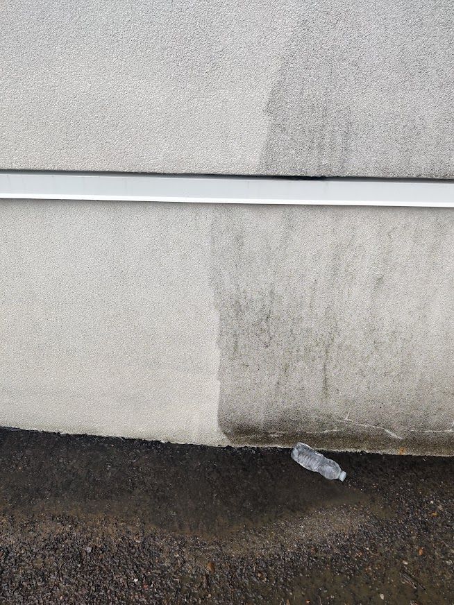 Un gros plan du côté d'une voiture avec une bouteille d'eau sur le sol.