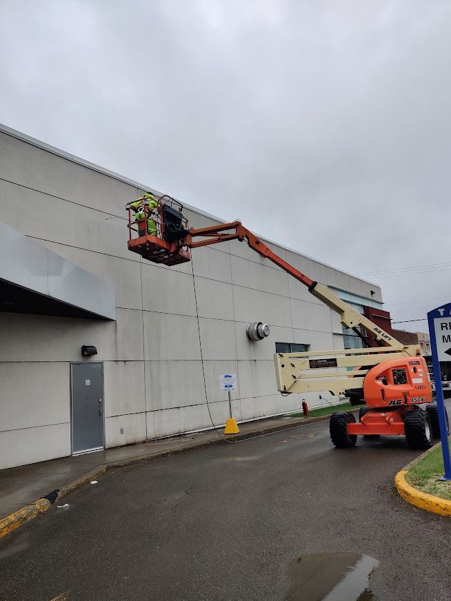 Un homme se tient debout sur un ascenseur devant un immeuble.