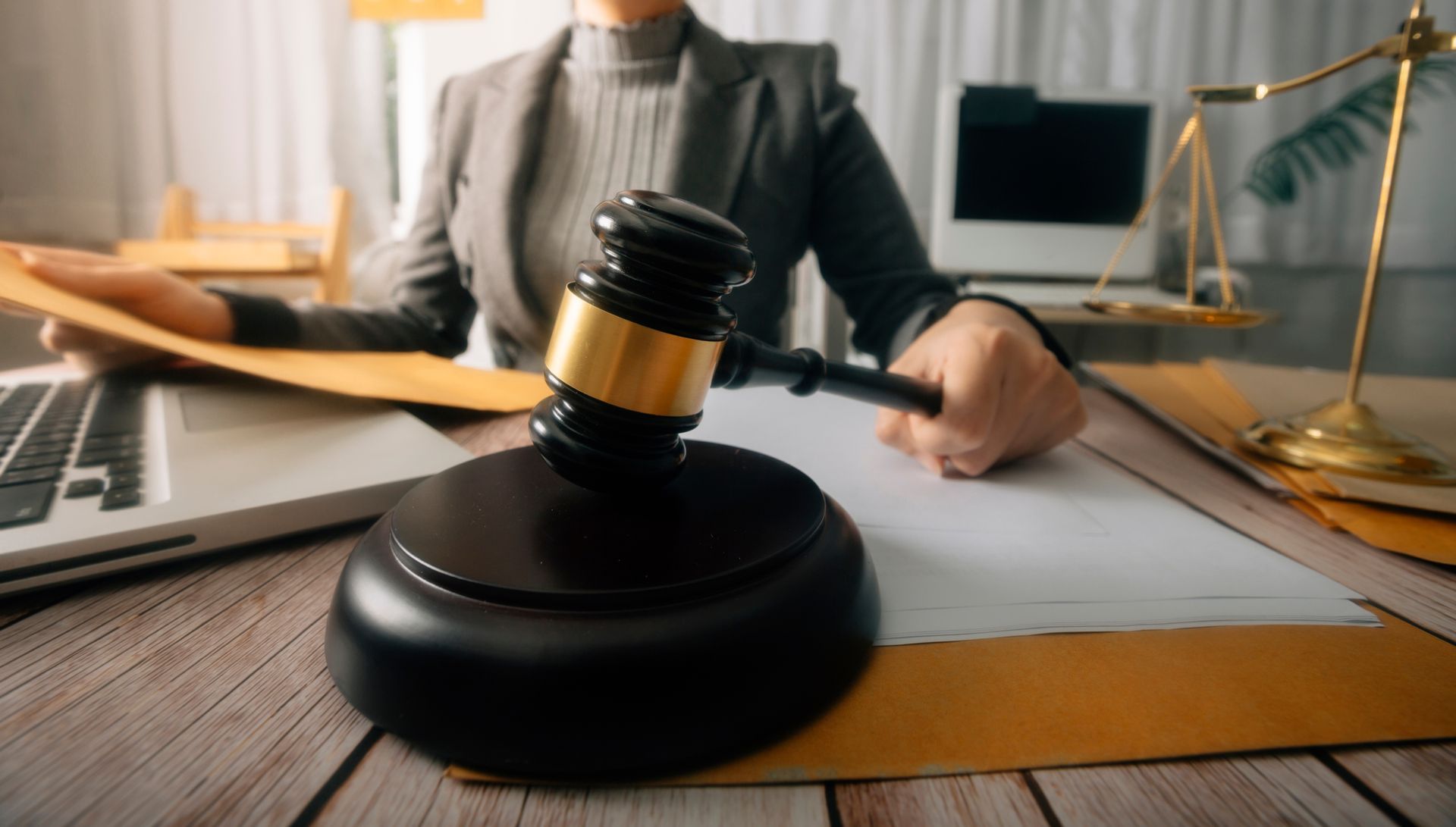 A judge is sitting at a desk holding a gavel.