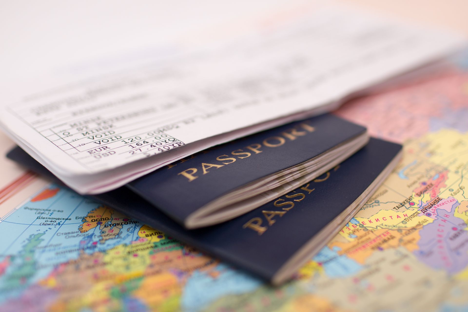 Three passports are stacked on top of each other on a map.