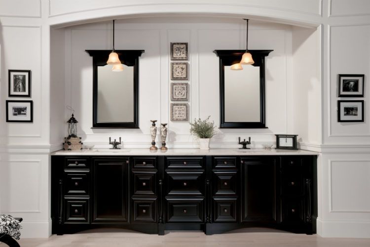 Elegant double vanity bathroom with black cabinets, white counters, and twin mirrors under pendant lights