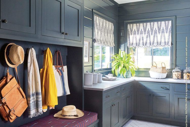 Mudroom with dark cabinets, hats and coats on hooks, and a bright kitchen window with plants and patterned blinds