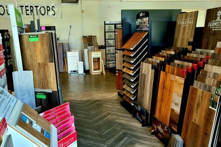 Flooring showroom with wood and laminate samples displayed on racks