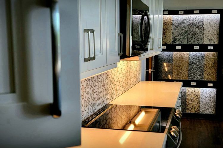 Modern kitchen with gray cabinets, black countertop, and frosted glass pantry doors
