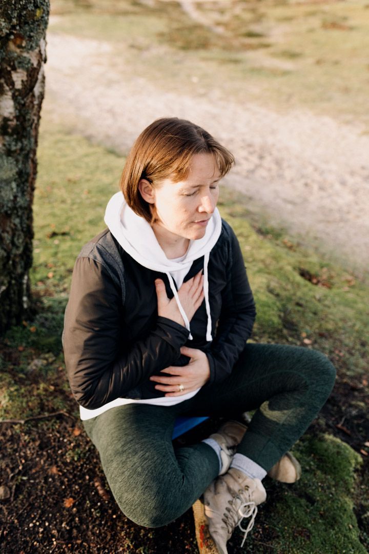 photo of a lady sitting calmly with hands on chest and relaxing