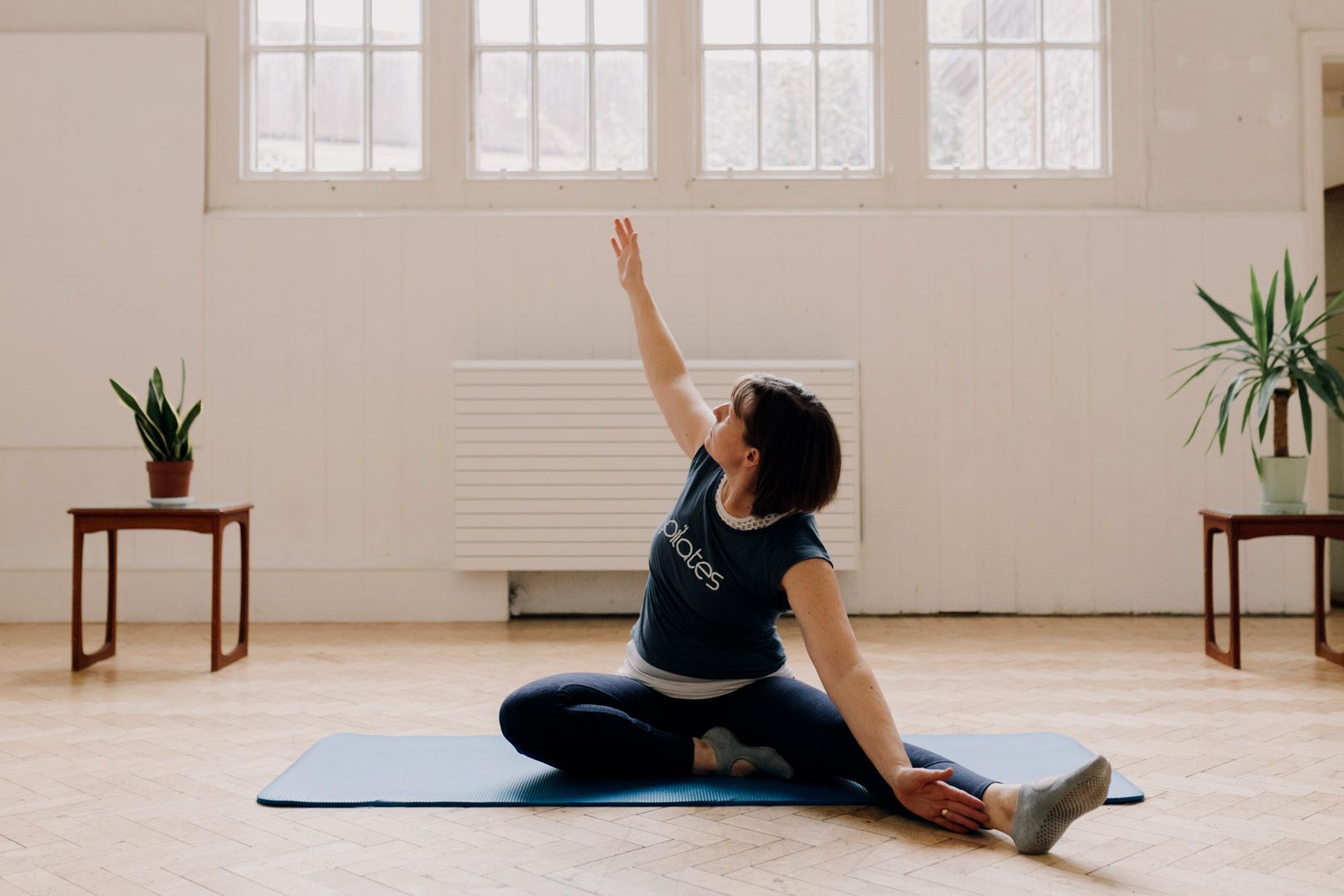 Photo of Pilates instructor doing a seated arm and chest stretch