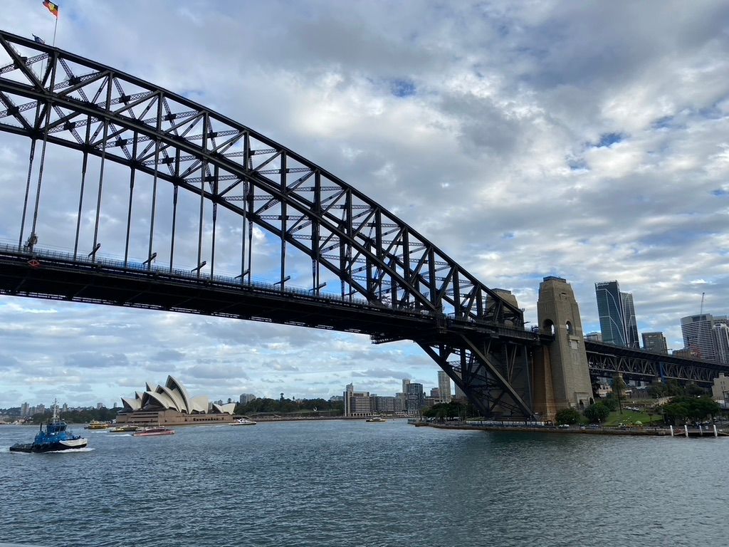 photo of Sydney harbour bridge from underneath with the opera house in the background