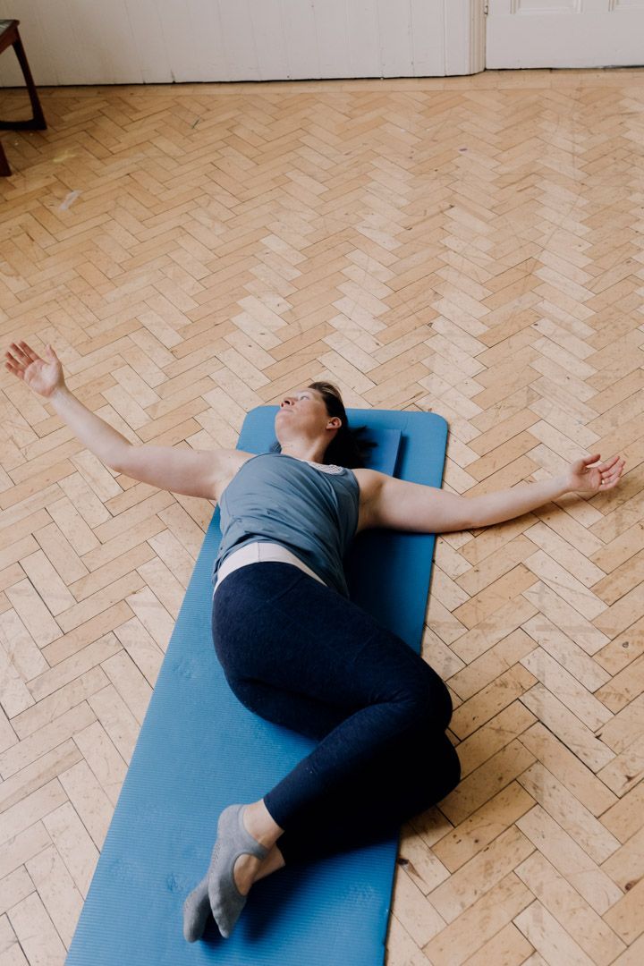 photo of a lady on her side, twisting backwards with her arm lifted