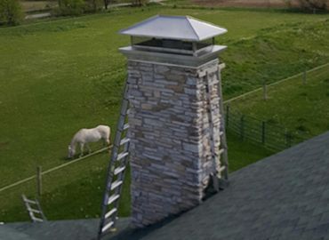 A horse is grazing next to a chimney on a roof.